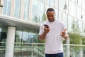 African american man talking on smartphone on street in city outdoor. Man with cell phone chatting with friends. Smiling Royalty Free Stock Photo