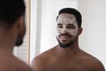 African american man use facial beauty mask in bathroom