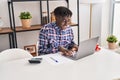 African american man using laptop sitting on table at home Royalty Free Stock Photo