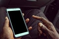 African American man using mobile smart phone with blank black screen. Mock up of a Black man holding device and touching screen. Royalty Free Stock Photo