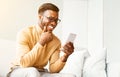 African American Man Using Smatphone Texting And Laughing Sitting Indoor Royalty Free Stock Photo
