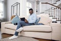 African american man using tablet on comfy couch Royalty Free Stock Photo