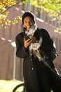 African american man walking in city with mobile phone and winter jacket Royalty Free Stock Photo