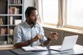 African American man wearing headphones speaking, using laptop Royalty Free Stock Photo