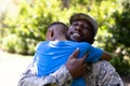 African American man wearing a military uniform holding his son Royalty Free Stock Photo