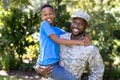 African American man wearing a military uniform holding his son Royalty Free Stock Photo