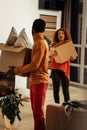 African-American man wearing red trousers caring box with cushions