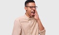 African American man wearing round eyewear, beige shirt and wide opened mouth screaming with great fear and anger. Furious dark- Royalty Free Stock Photo