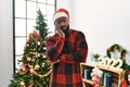 African american man wearing santa claus hat standing by christmas tree thinking looking tired and bored with depression problems Royalty Free Stock Photo