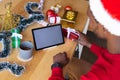 African american man wearing santa hat, using tablet with copyspace Royalty Free Stock Photo