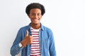 African american man wearing striped t-shirt and denim jacket over isolated white background doing happy thumbs up gesture with Royalty Free Stock Photo