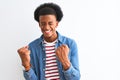 African american man wearing striped t-shirt and denim jacket over isolated white background very happy and excited doing winner Royalty Free Stock Photo