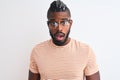 African american man wearing striped t-shirt and glasses over isolated white background afraid and shocked with surprise Royalty Free Stock Photo