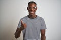 African american man wearing striped t-shirt and glasses over isolated white background doing happy thumbs up gesture with hand Royalty Free Stock Photo