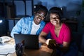 African american man and woman business workers using laptop and smartphone at office