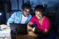 African american man and woman business workers using laptop and smartphone at office