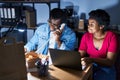 African american man and woman business workers using laptop talking on the telephone at office