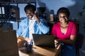 African american man and woman business workers using laptop talking on the telephone at office