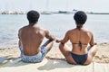 African american man and woman couple wearing swimsuit doing yoga exercise at seaside Royalty Free Stock Photo