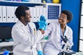 African american man and woman scientists high five with hands raised up at laboratory Royalty Free Stock Photo