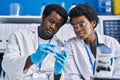 African american man and woman scientists holding sample at laboratory