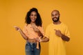 African american man and woman smiling and gesturing aside