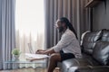 African American man working with laptop computer remote while sitting at sofa in living room. Black guy do freelance Royalty Free Stock Photo