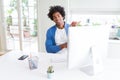 African American man working using computer with a big smile on face, pointing with hand and finger to the side looking at the Royalty Free Stock Photo