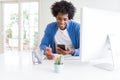 African American man working using smartphone and computer with a happy face standing and smiling with a confident smile showing Royalty Free Stock Photo