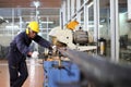 African American mechanic engineer worker wearing safety equipment is cutting copper tube using sawing machine in the factory Royalty Free Stock Photo