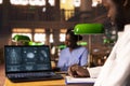 African american med student reading anatomy data under a green lamp Royalty Free Stock Photo