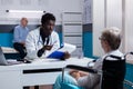 African american medic explaining diagnosis to old disabled woman Royalty Free Stock Photo