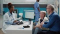 African american medic talking to elderly woman with disability