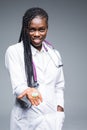 African American medical doctor holding pills,  on gray background Royalty Free Stock Photo