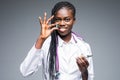 African American medical doctor holding pills, isolated on gray background Royalty Free Stock Photo