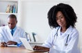 African american medical student working at computer with male scientist Royalty Free Stock Photo