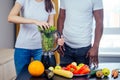 African american man with asian woman making smoothie at home Royalty Free Stock Photo