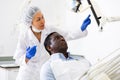 Man patient and woman dentist looking at monitor during consultation Royalty Free Stock Photo