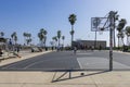 african american men playing basketball on a court at Venice Beach with tall lush green palm trees and a clear blue sky in Venice Royalty Free Stock Photo