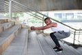 African-American men in sportswear are exercising outdoors by doing squats and looking camera Royalty Free Stock Photo