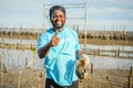 African American men volunteer thumbs up after helpers planting trees in mangrove forest for environmental protection and ecology