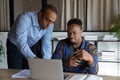 African American mentor teaching intern, pointing at laptop screen Royalty Free Stock Photo