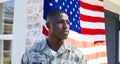 African american mid adult army soldier in camouflage clothing looking away standing against flag Royalty Free Stock Photo