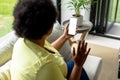 African american mid adult woman waving hand over smart phone during video call Royalty Free Stock Photo