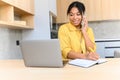 African-American millennial woman remote studying or working, talking on the smartphone and using laptop. Female Royalty Free Stock Photo