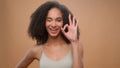 African American model woman beautiful attractive girl in beige studio background beauty procedure showing ok smiling at Royalty Free Stock Photo