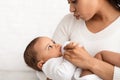 African American Mom Feeding Baby Giving Bottle With Milk Indoors Royalty Free Stock Photo
