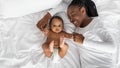 African American mom lying in bed with her cute infant Royalty Free Stock Photo