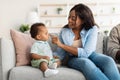 African American mom playing with her cute baby on couch Royalty Free Stock Photo