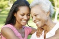 African American Mother And Adult Daughter Relaxing In Park